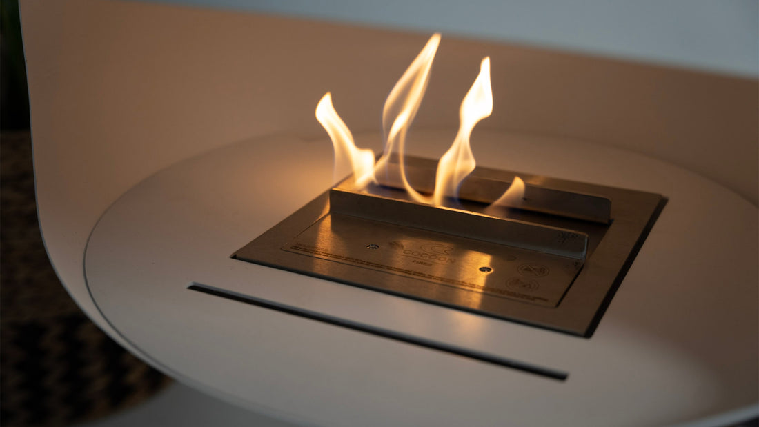 Cocoon Aeris white suspended fireplace with close-up bioethanol flame